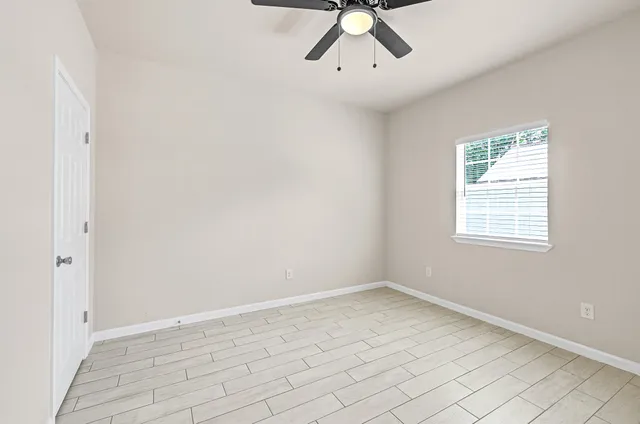 wooden floor in an empty room with a window