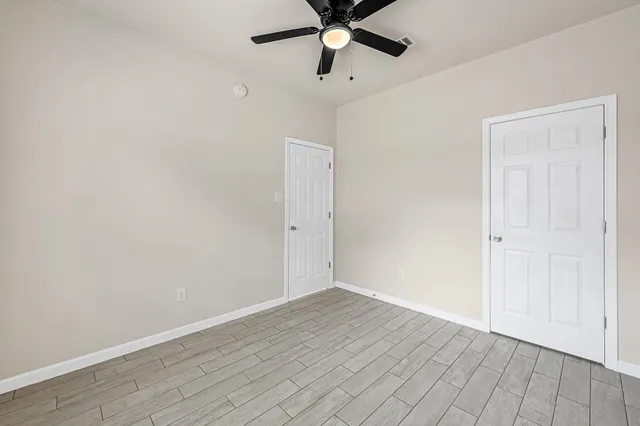 a view of an empty room with wooden floor