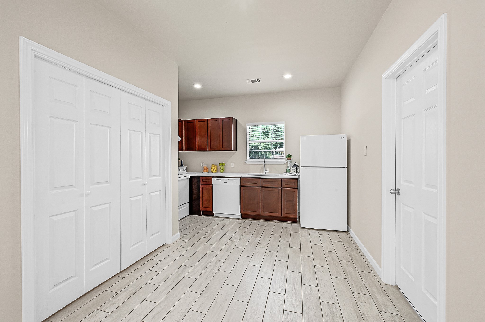 20603 Marilyn Lane, Unit B Spring, TX 77388 - Photo 8 of 18 a large white kitchen with a sink and dishwasher a refrigerator with wooden floor