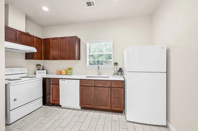a kitchen with a sink a refrigerator and cabinets