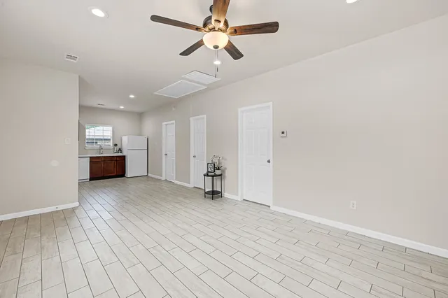 a view of empty room with wooden floor and ceiling fan