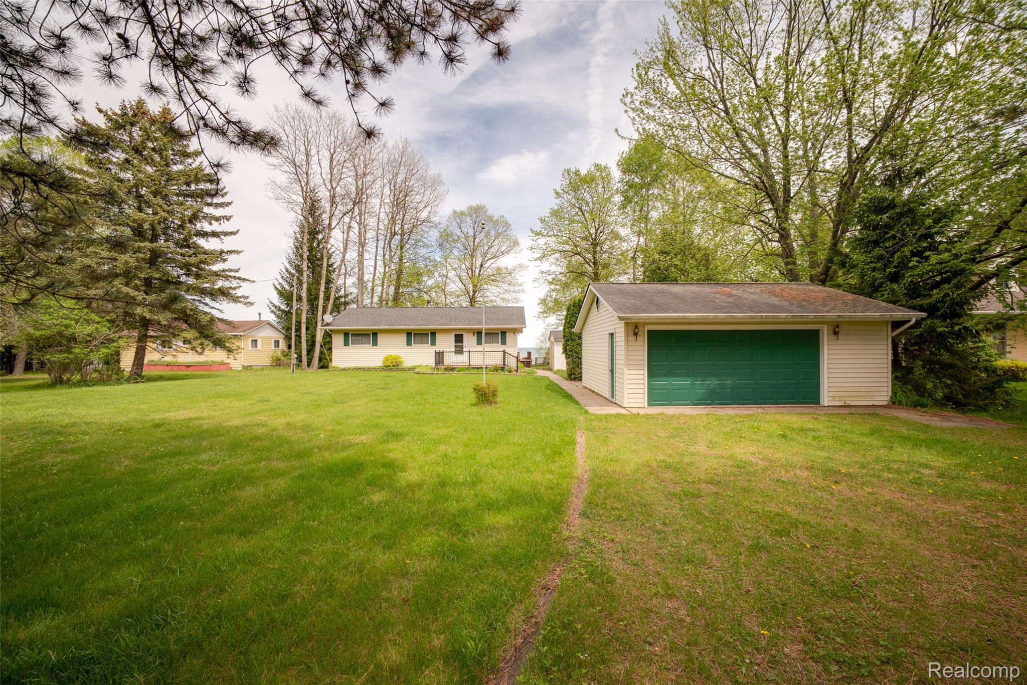 6240 Lakeshore Road Palms, MI 48465 - Photo 28 of 38 Back of property featuring a garage, a yard, and an outbuilding