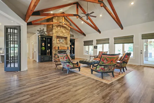 a kitchen with stainless steel appliances granite countertop a stove top oven a sink dishwasher a dining table and chairs with wooden floor