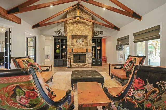 a living room with furniture a piano and a bookshelf