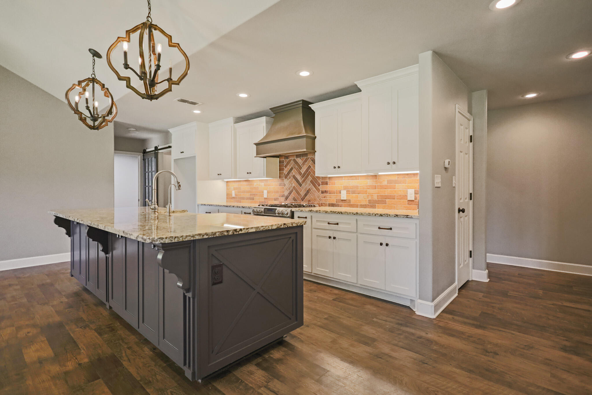 7002 50th Street Lubbock, TX 79407 - Photo 57 of 81 a kitchen with kitchen island granite countertop a sink cabinets and wooden floor