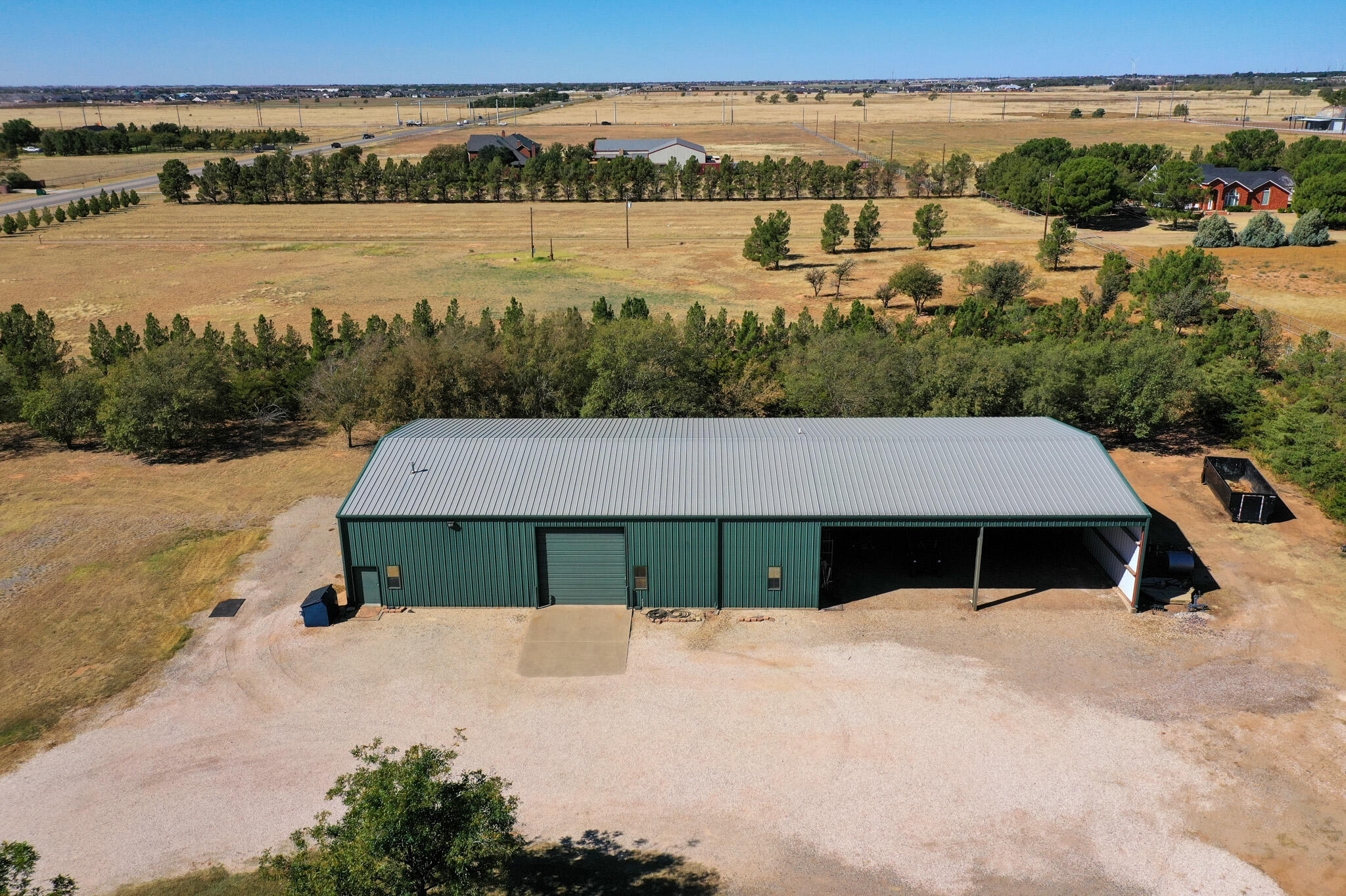 7002 50th Street Lubbock, TX 79407 - Photo 9 of 81 an aerial view of a house with large trees and lake view