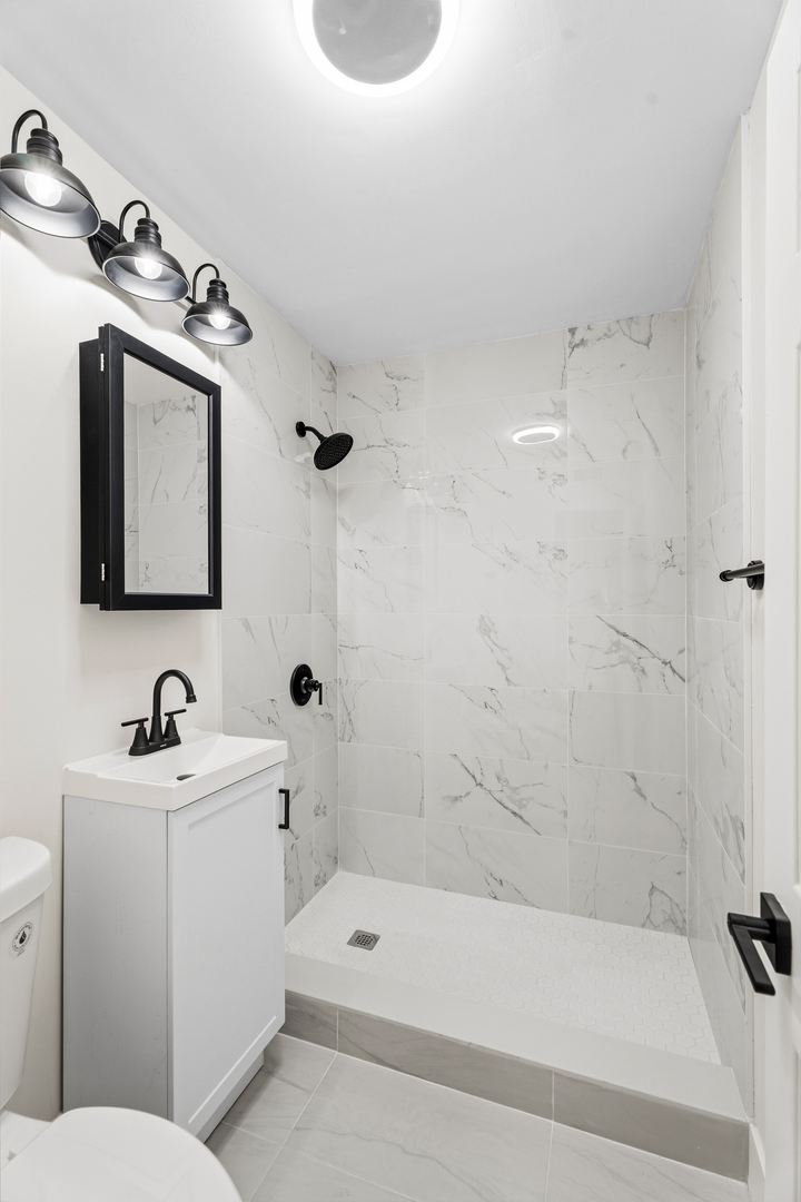 409 Winnemac Street Park Forest, IL 60466 - Photo 13 of 21 a bathroom with a sink a toilet and bathtub