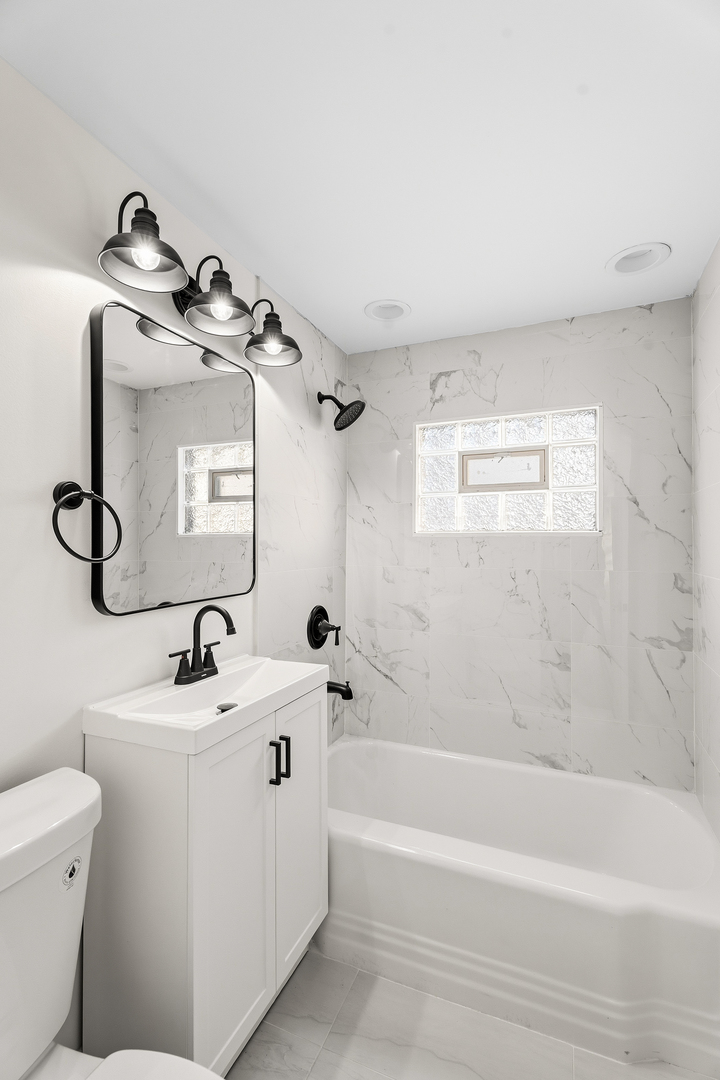 409 Winnemac Street Park Forest, IL 60466 - Photo 17 of 21 a bathroom with a toilet a sink and mirror