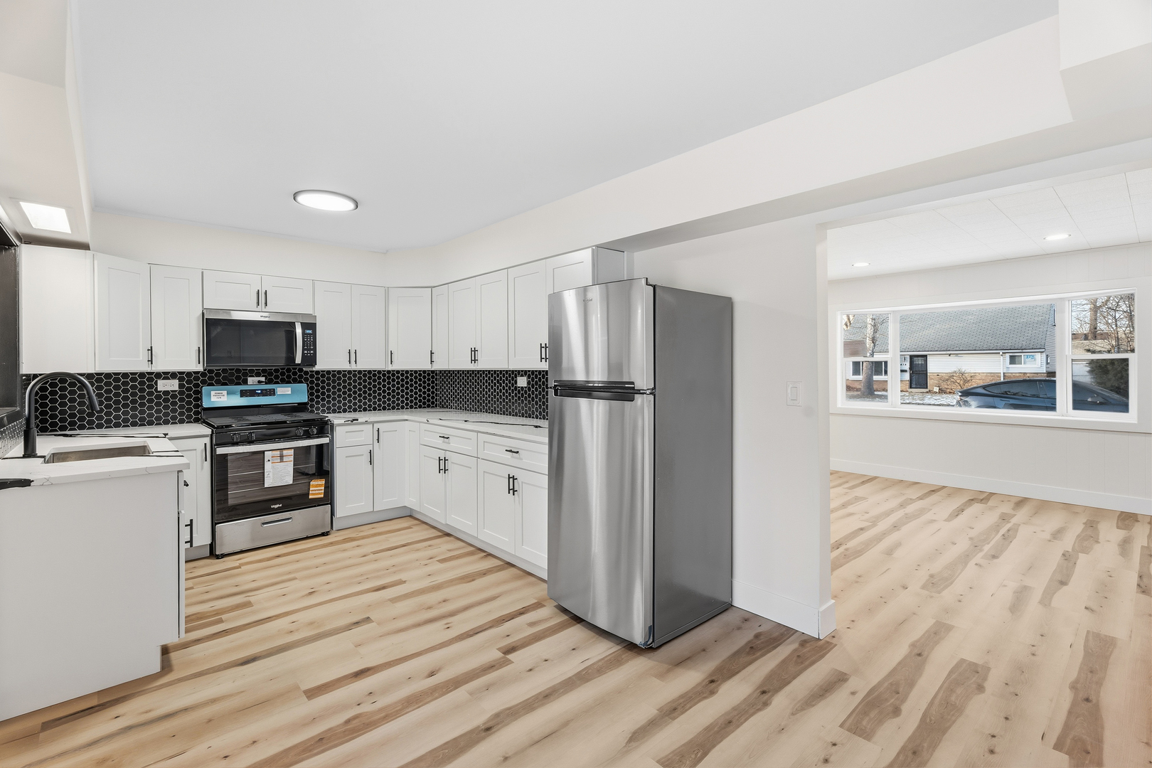 409 Winnemac Street Park Forest, IL 60466 - Photo 6 of 21 a kitchen with a refrigerator stove and white cabinets