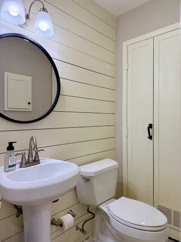 a bathroom with a sink a toilet and mirror