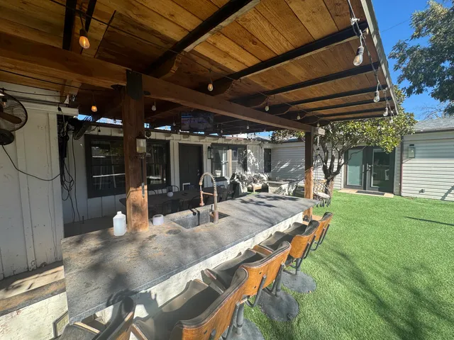 a view of a backyard with seating space and swimming pool