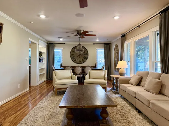 a living room with furniture a rug and a clock