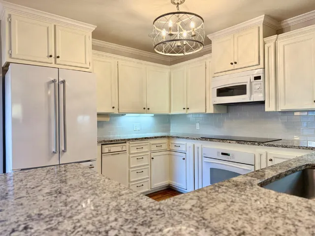 a kitchen with stainless steel appliances granite countertop a stove a sink and a refrigerator