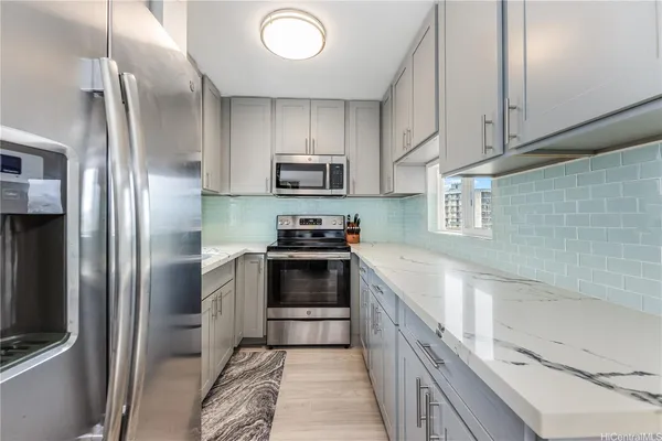 a kitchen with stainless steel appliances granite countertop a refrigerator a stove and a sink