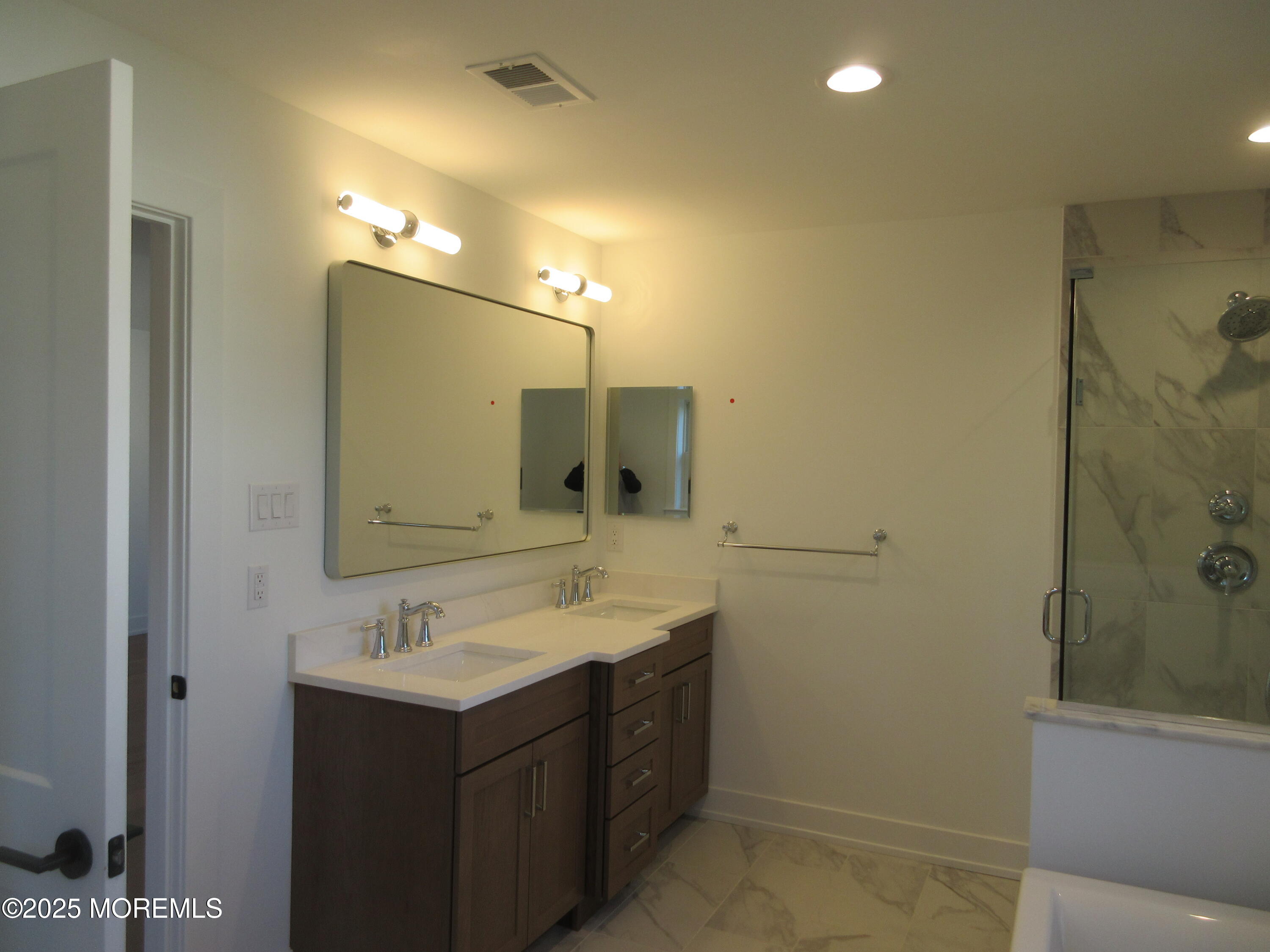 129 Crine Road Morganville, NJ 07751 - Photo 20 of 23 a bathroom with a sink double vanity and a mirror