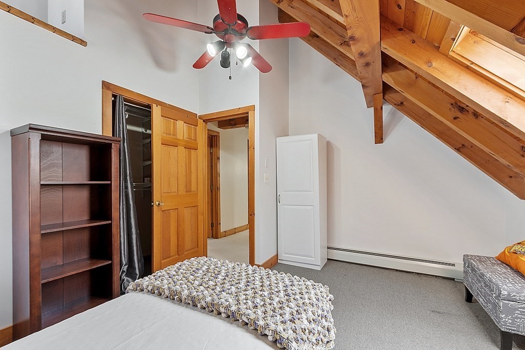 149 Walker Pond Road Sturbridge, MA 01566 - Photo 20 of 42 a bedroom with a bed and a chandelier