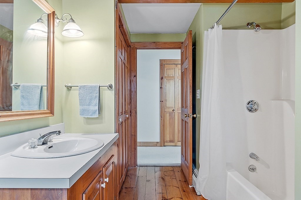 149 Walker Pond Road Sturbridge, MA 01566 - Photo 23 of 42 a bathroom with a sink a mirror and a bathtub