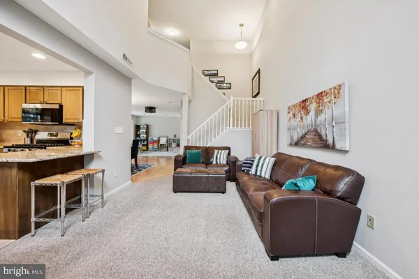 a living room with furniture and kitchen view