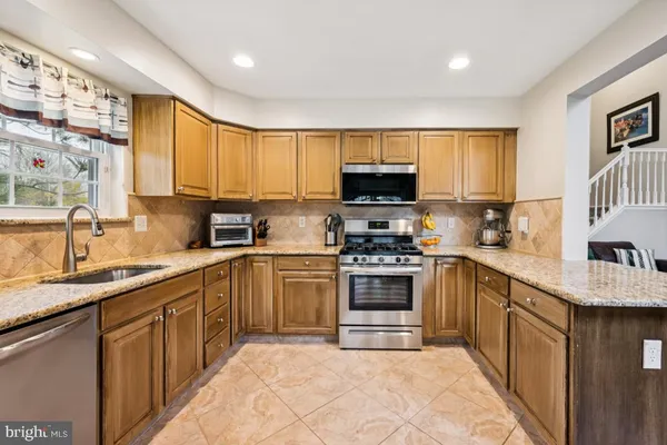 a kitchen with stainless steel appliances granite countertop a refrigerator stove microwave and sink
