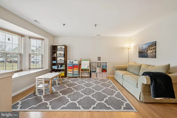 a living room with furniture a flat screen tv and a window