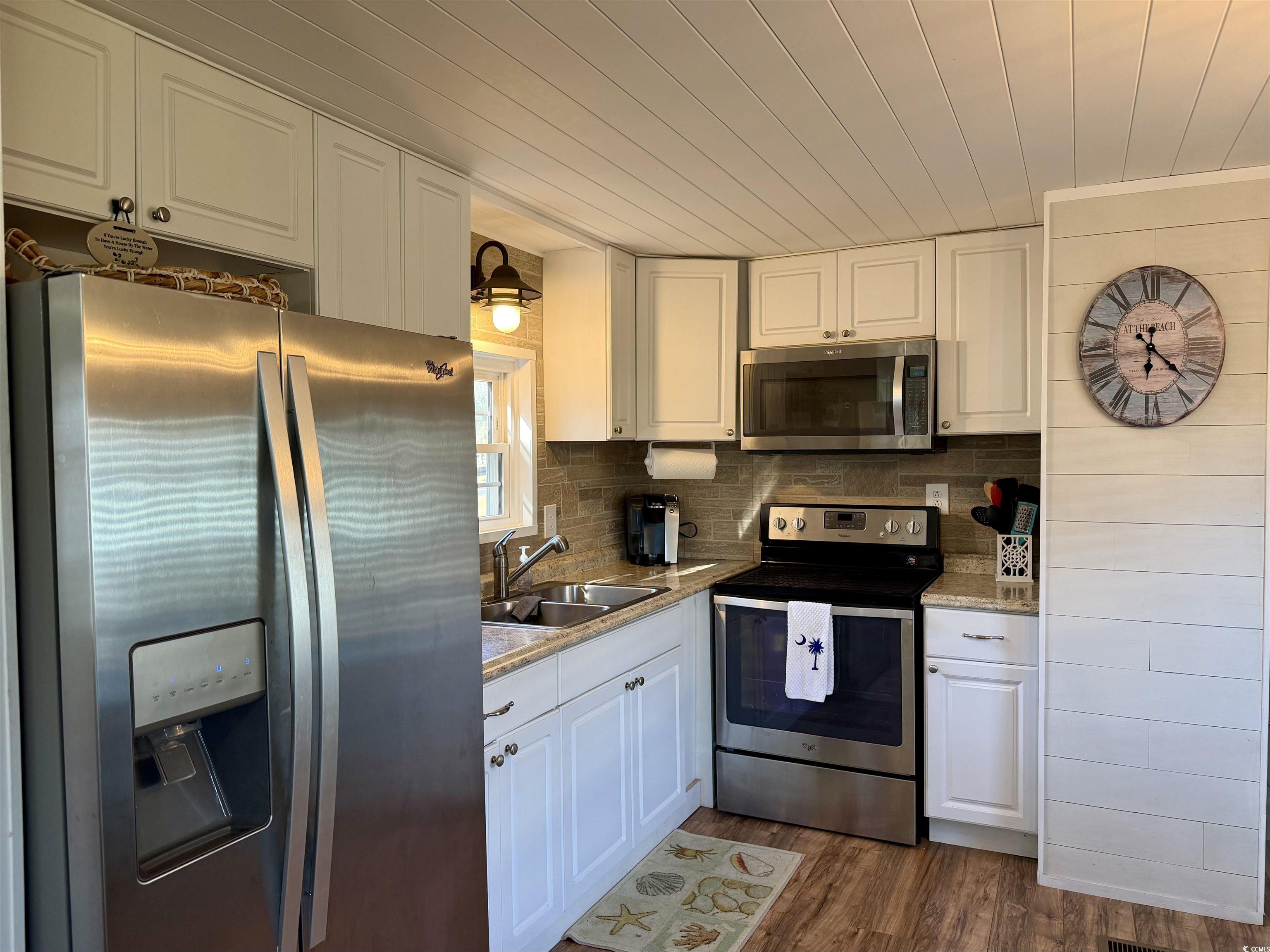 292 Flamingo Surfside Beach, SC 29575 - Photo 8 of 32 Kitchen with stainless steel appliances, white cabinetry, dark wood-style floors, wood ceiling, and decorative backsplash