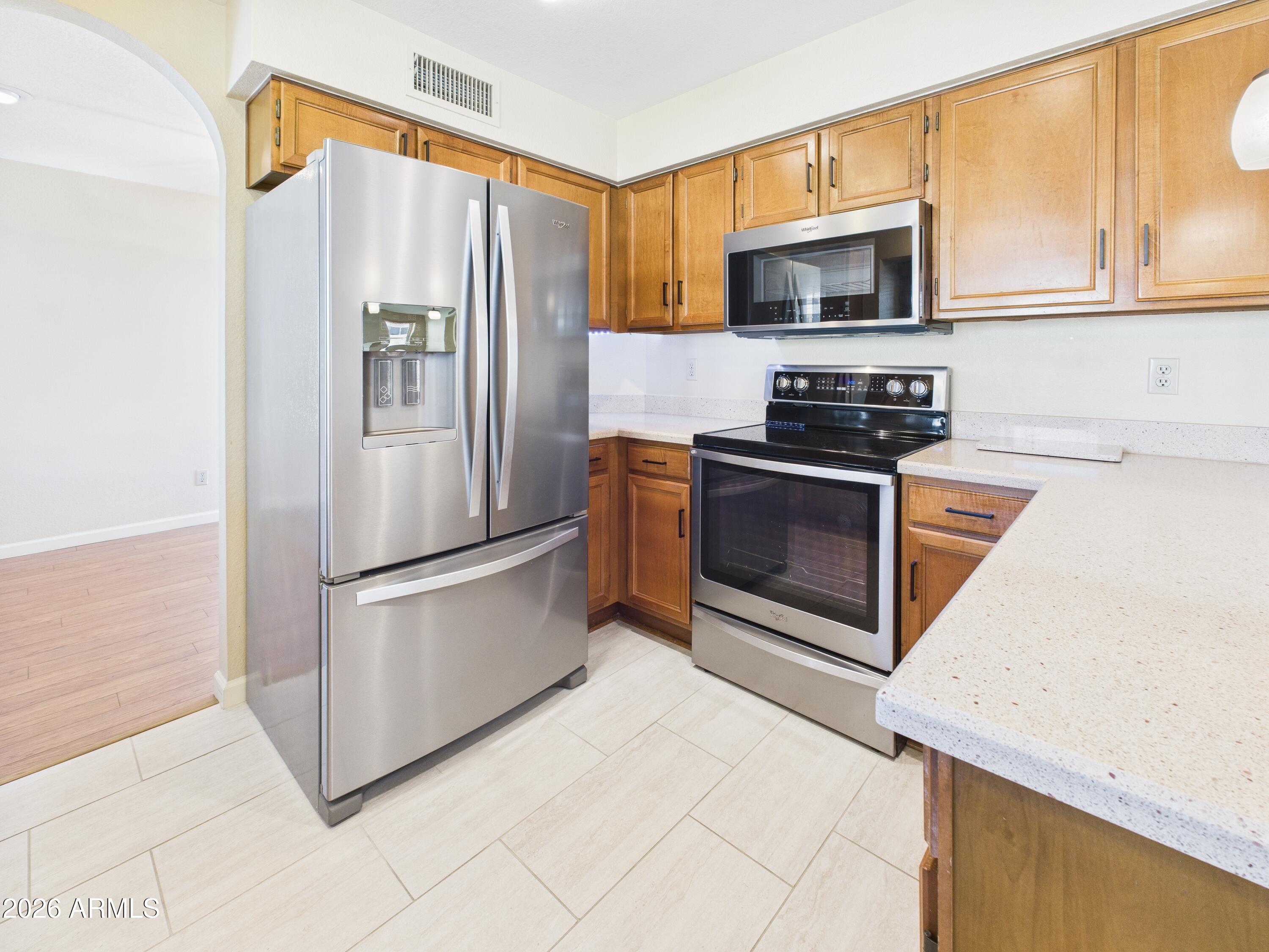 2750 East Rock Wren Road Phoenix, AZ 85048 - Photo 11 of 90 a kitchen with stainless steel appliances granite countertop a refrigerator stove top oven and sink
