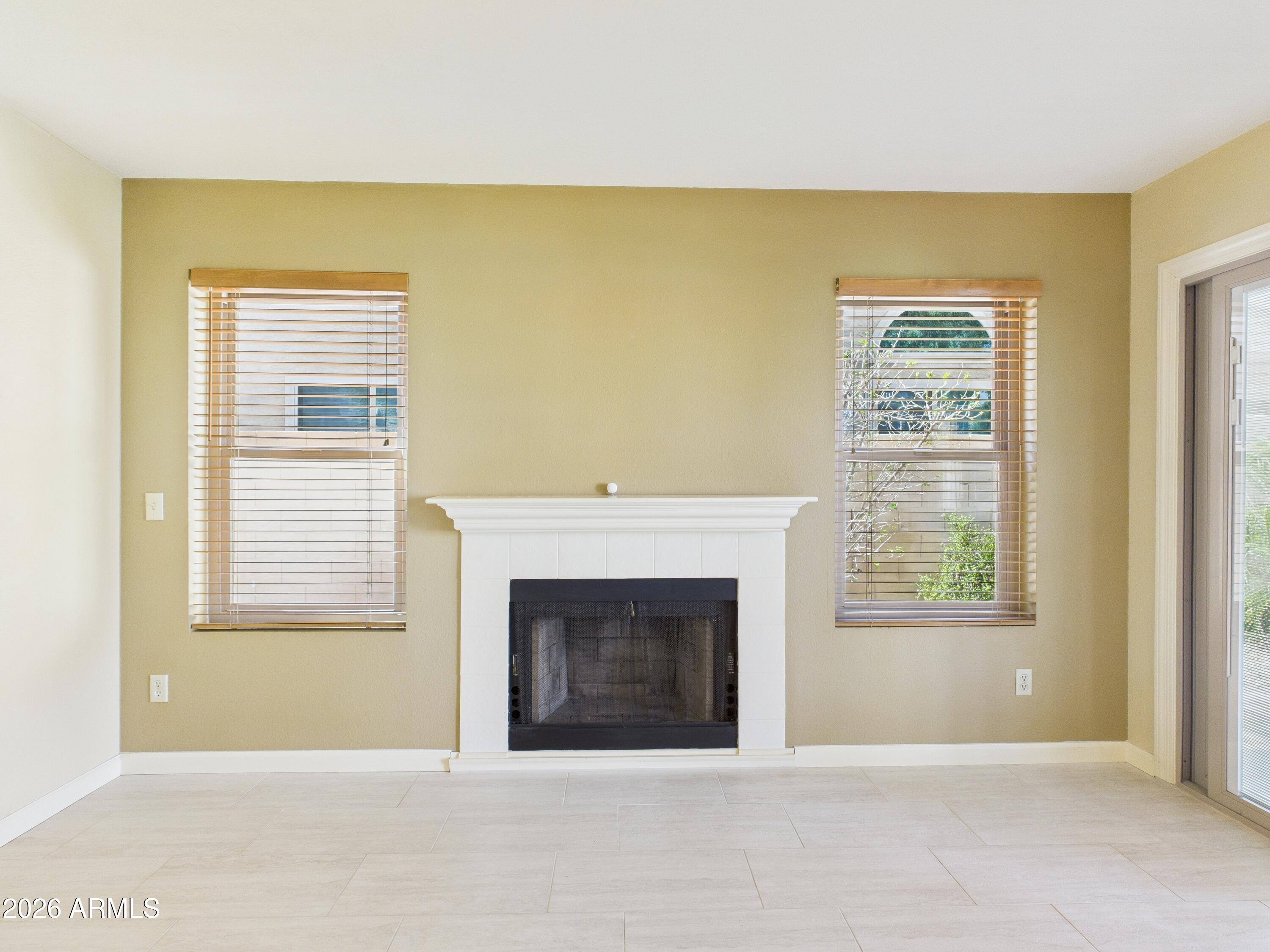 2750 East Rock Wren Road Phoenix, AZ 85048 - Photo 19 of 90 a view of an empty room with a fireplace and a window
