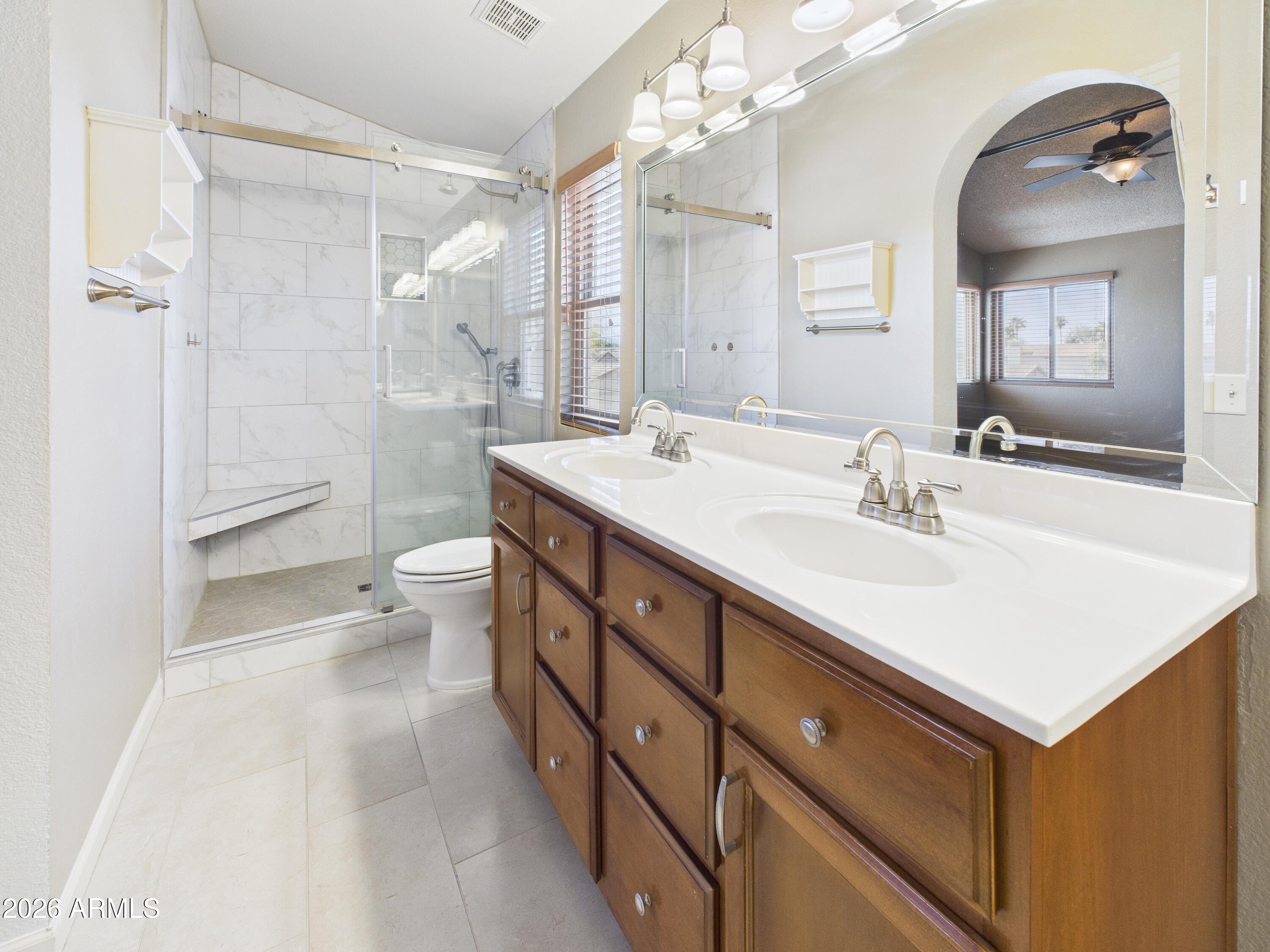 2750 East Rock Wren Road Phoenix, AZ 85048 - Photo 34 of 90 a bathroom with a sink a toilet a mirror and shower