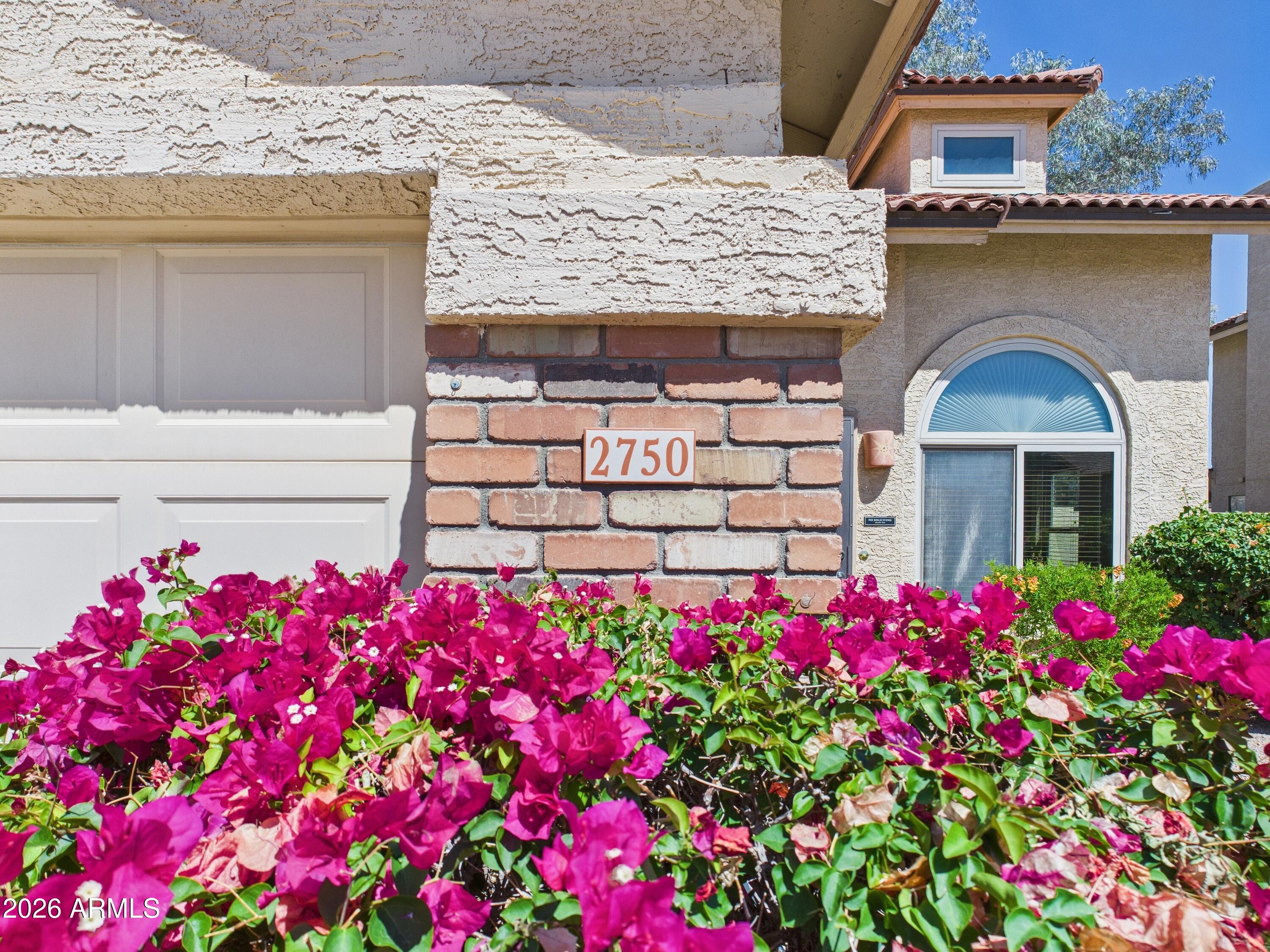 2750 East Rock Wren Road Phoenix, AZ 85048 - Photo 3 of 90 a front view of a house with lots of flowers