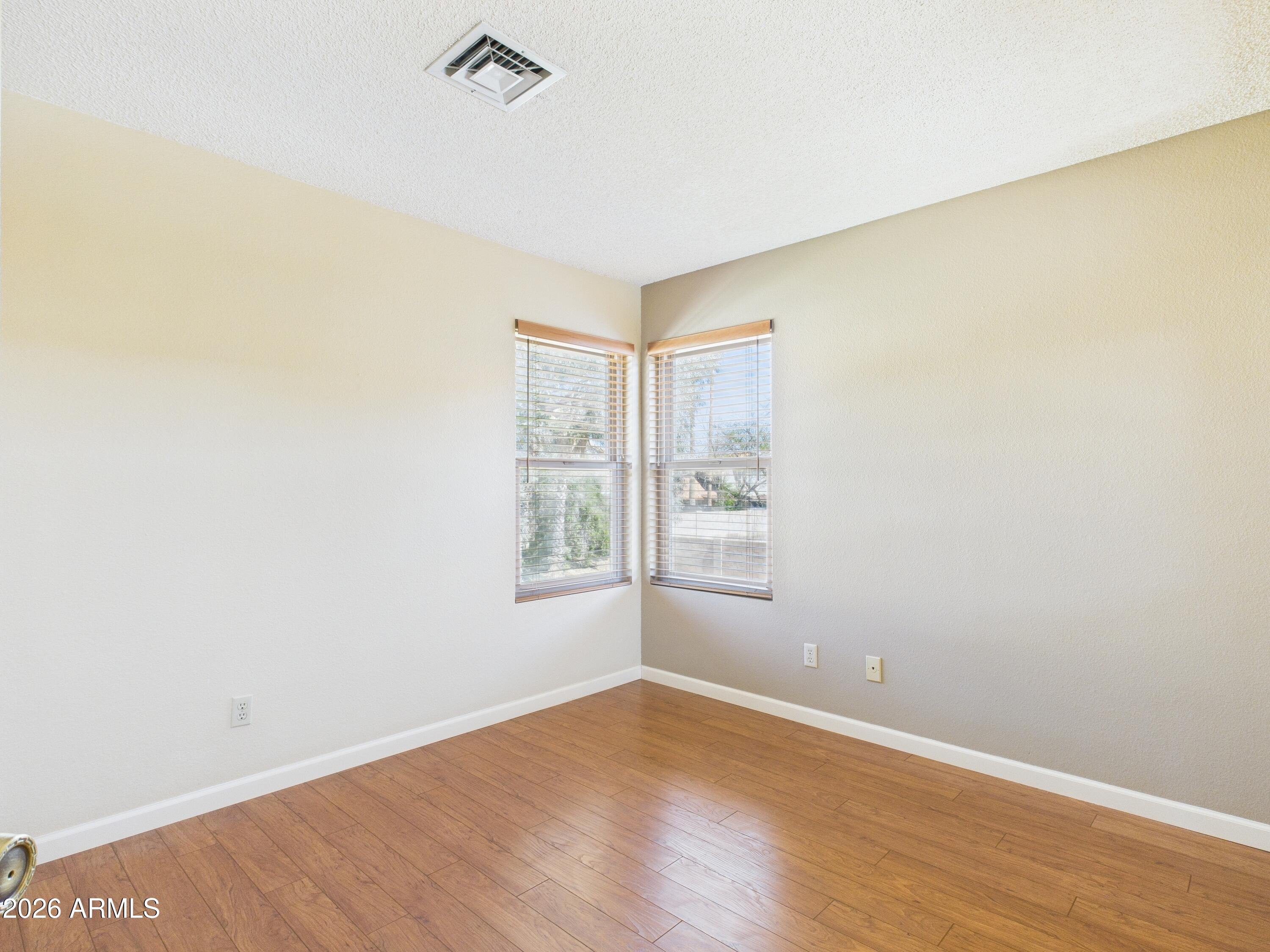 2750 East Rock Wren Road Phoenix, AZ 85048 - Photo 40 of 90 an empty room with wooden floor and windows