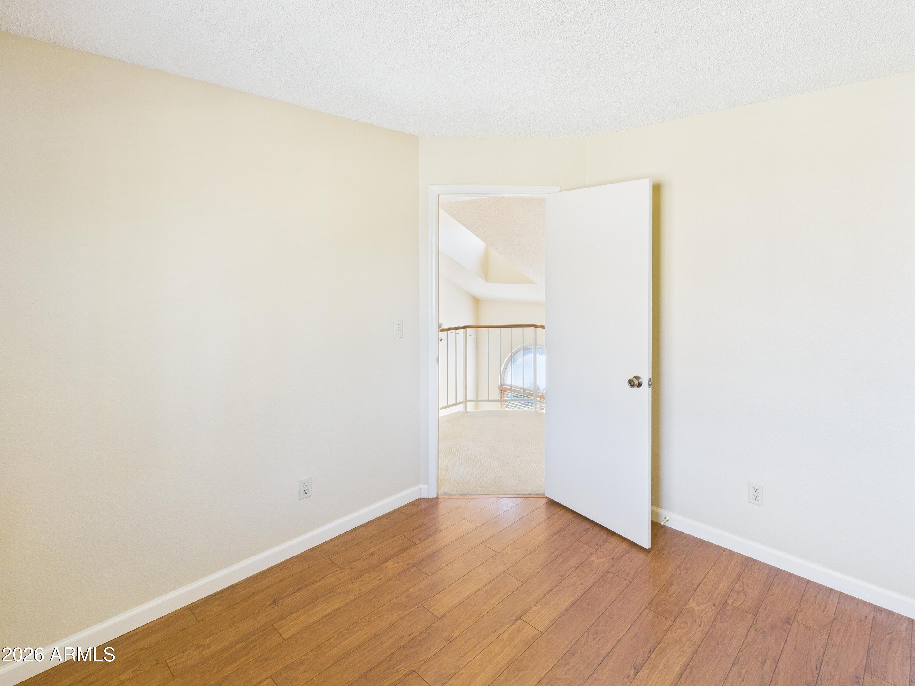 2750 East Rock Wren Road Phoenix, AZ 85048 - Photo 47 of 90 a view of an empty room with wooden floor and a window
