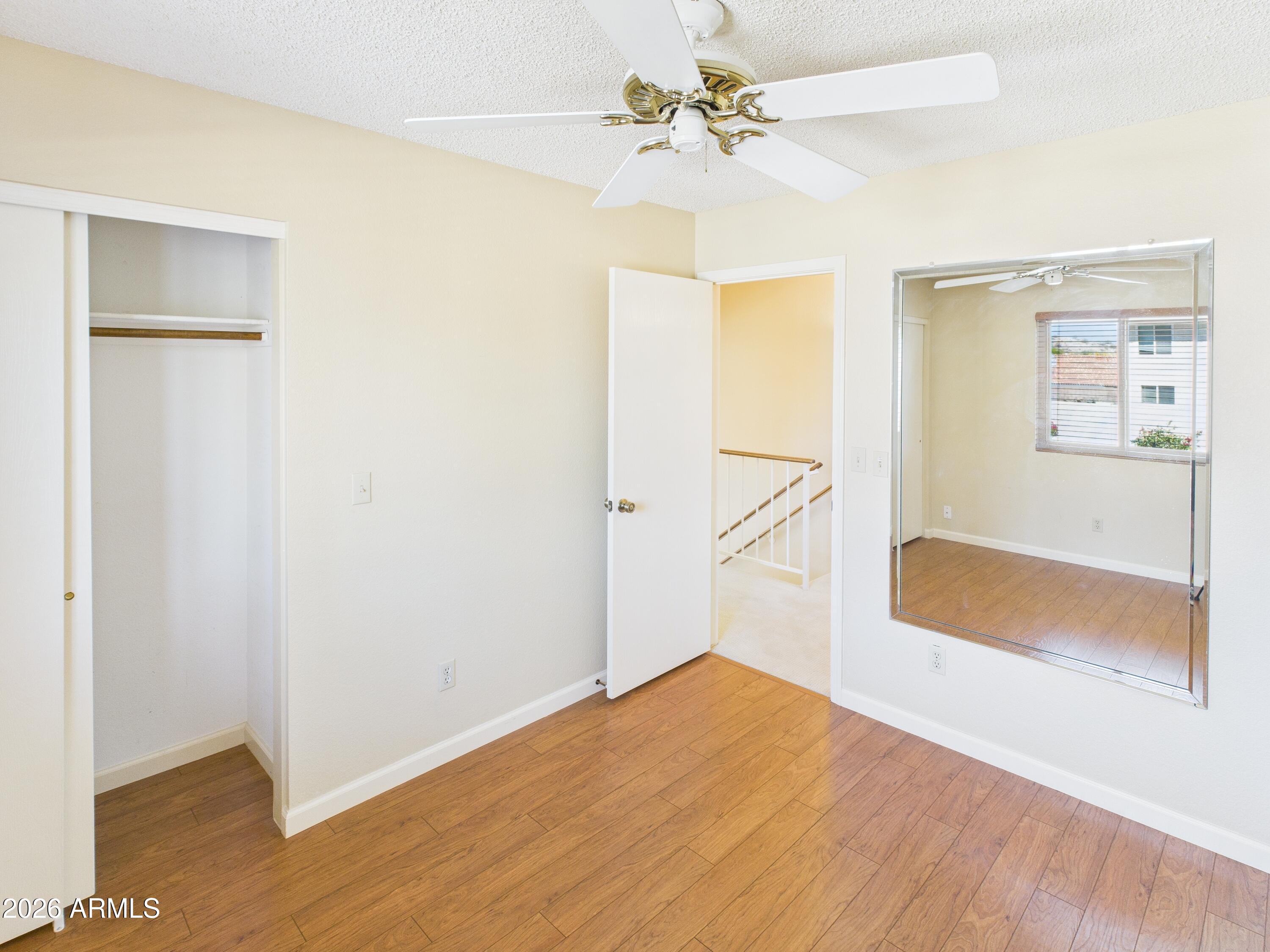 2750 East Rock Wren Road Phoenix, AZ 85048 - Photo 48 of 90 a view of a bedroom with wooden floor and a ceiling fan