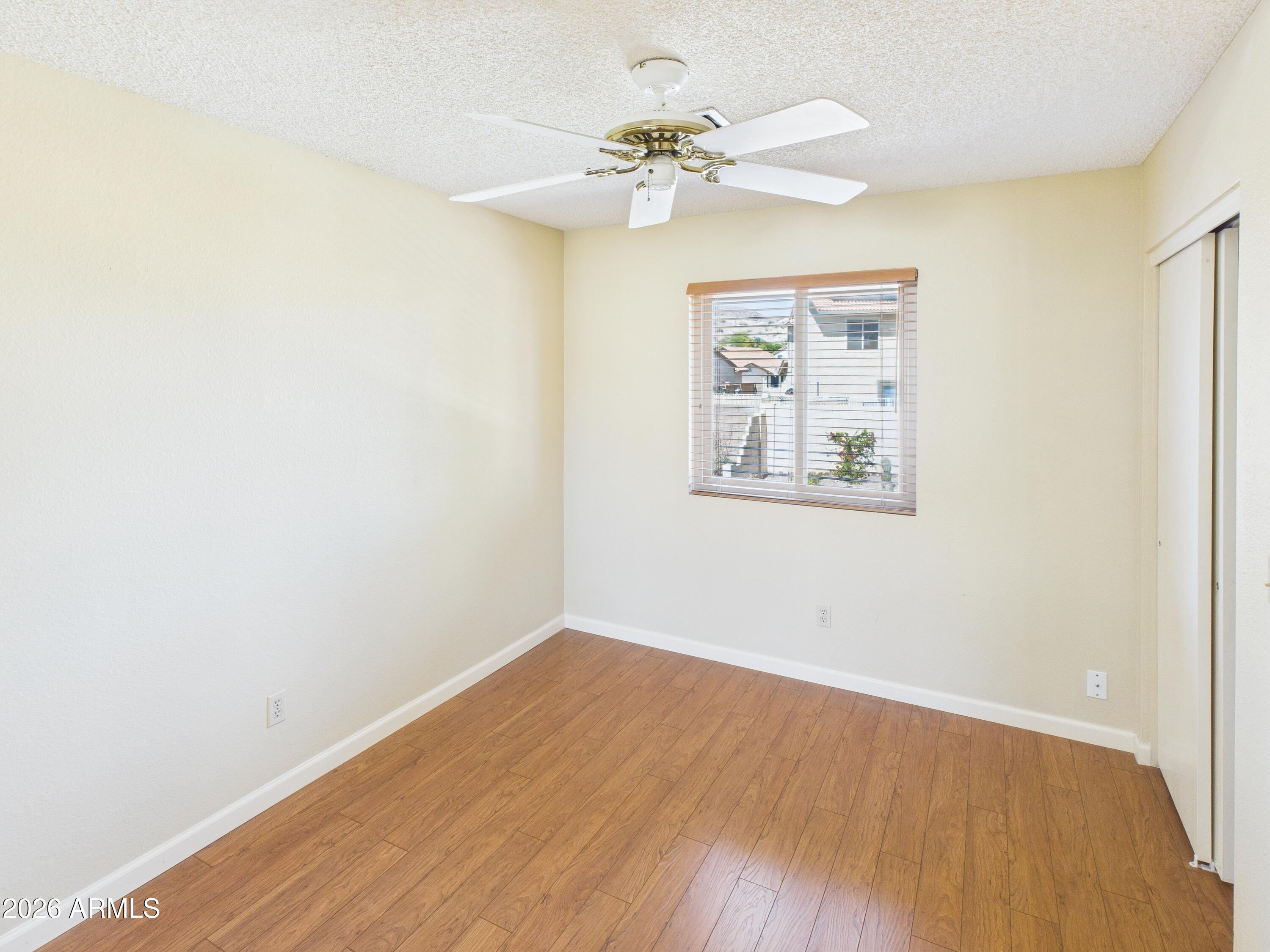 2750 East Rock Wren Road Phoenix, AZ 85048 - Photo 49 of 90 an empty room with a window and a chandelier fan
