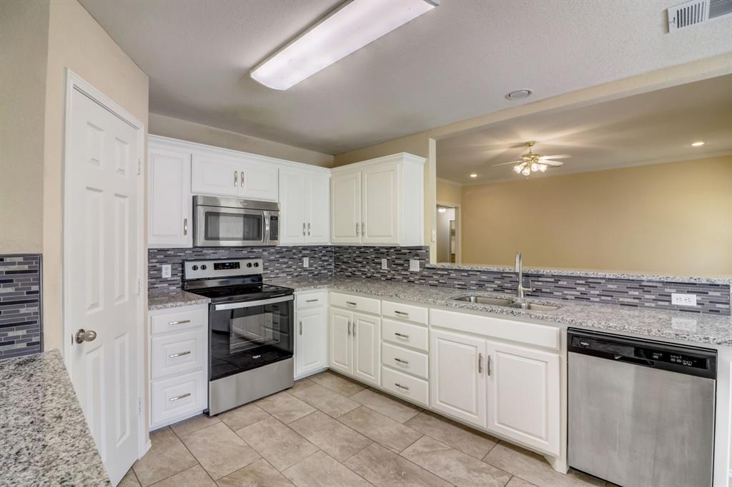 a kitchen with stainless steel appliances granite countertop a stove sink and microwave