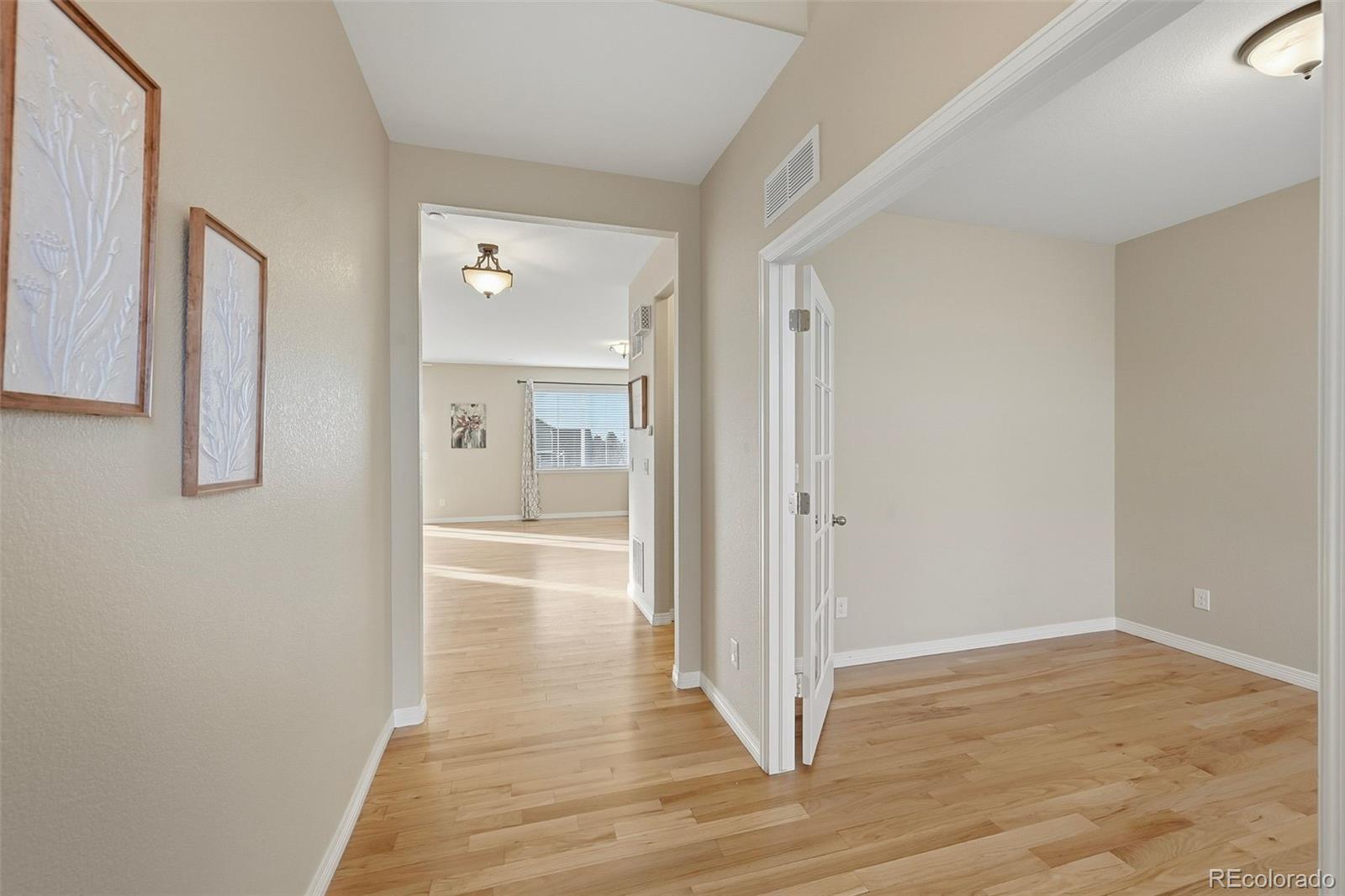 35 North Newcastle Way Aurora, CO 80018 - Photo 2 of 45 a view of a hallway with wooden floor and bathroom
