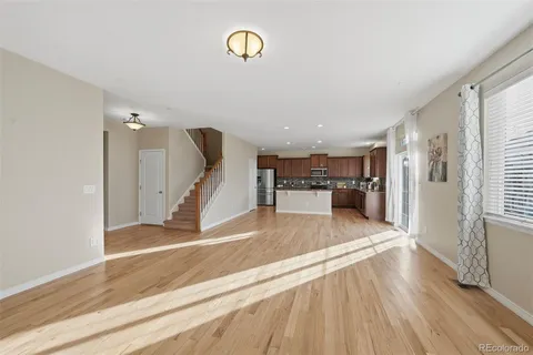 a view of a livingroom with wooden floor and stairs