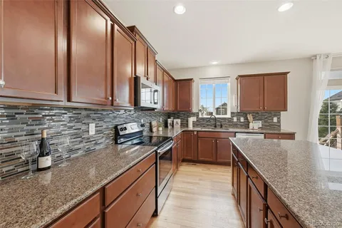 a kitchen with stainless steel appliances granite countertop a sink a stove and cabinets