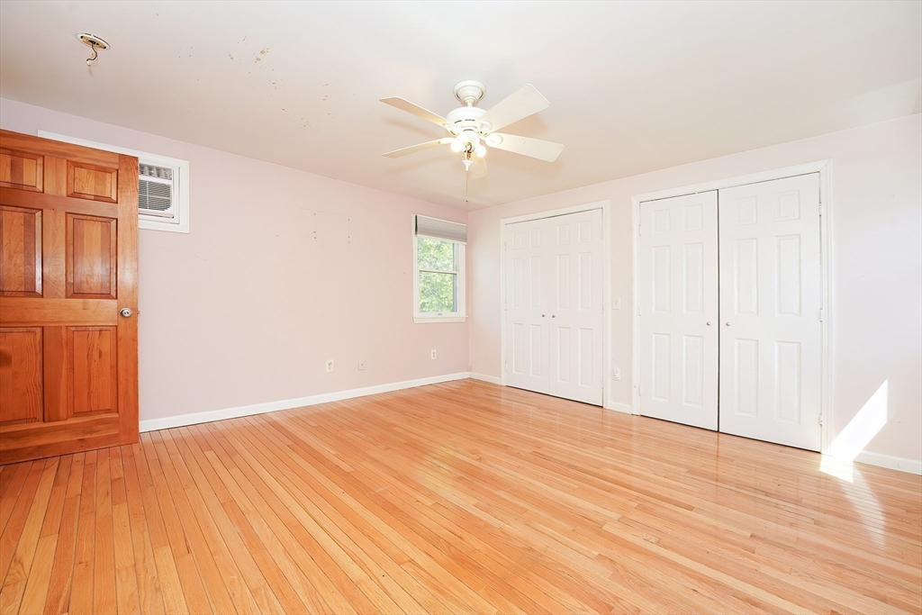 456 Gleasondale Road Stow, MA 01775 - Photo 21 of 30 a view of an empty room with wooden floor and a window