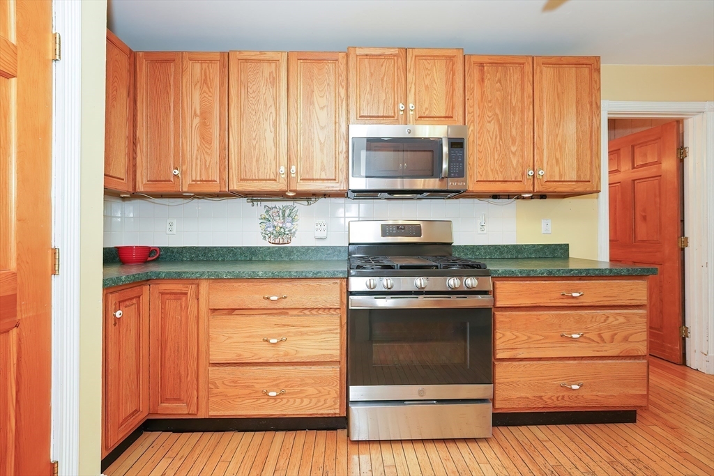 456 Gleasondale Road Stow, MA 01775 - Photo 9 of 30 a kitchen with stainless steel appliances granite countertop a stove microwave and cabinets