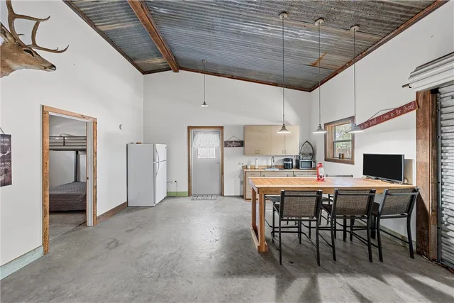 a kitchen with stainless steel appliances a table chairs refrigerator and cabinets