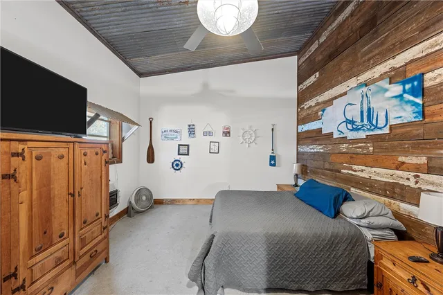 a bedroom with a bed and a flat tv screen on the wall