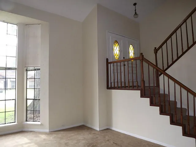 a view of hallway with stairs and wooden floor