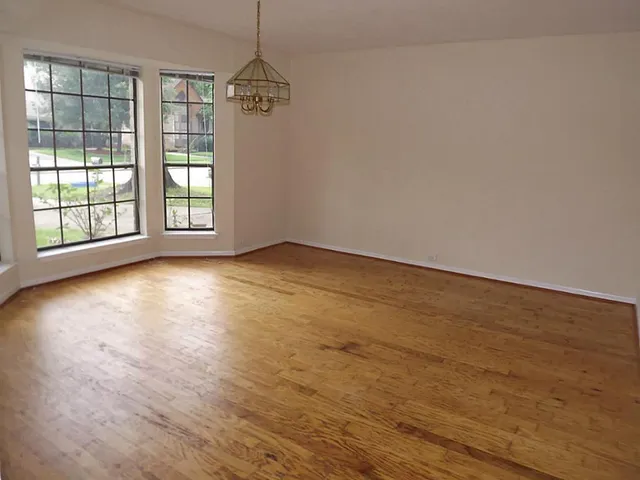 wooden floor in an empty room with a window