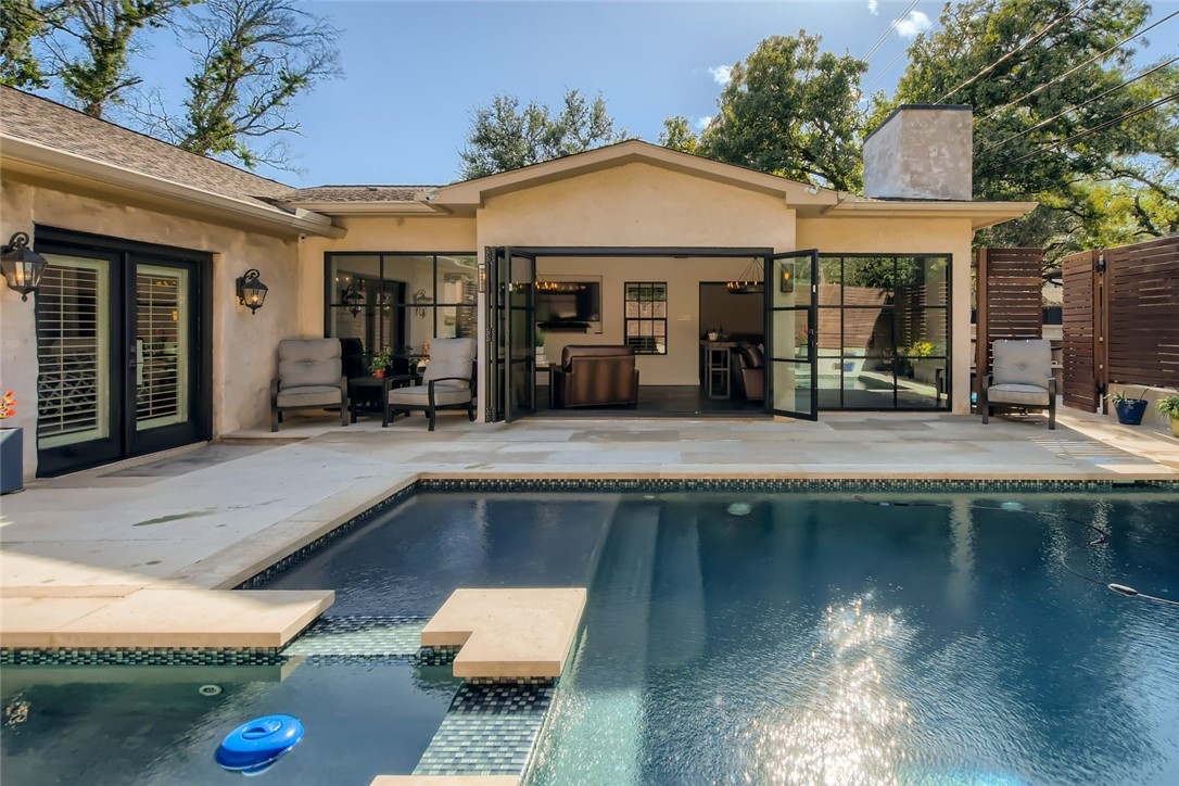 a front view of a house with swimming pool table and chairs