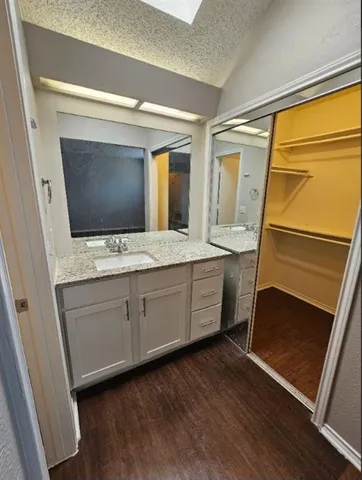 a bathroom with a granite countertop sink mirror and a bathtub