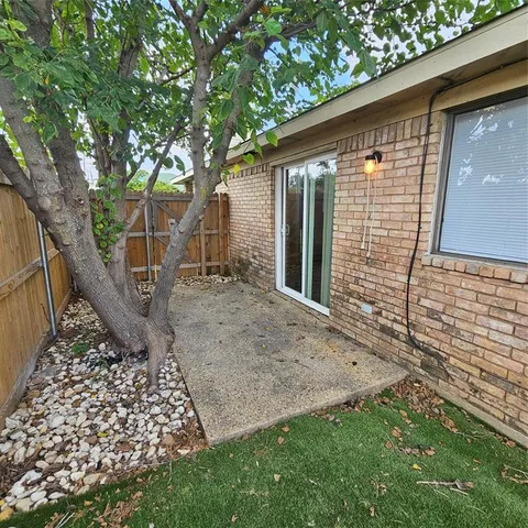 a view of a backyard with a garden and wooden fence