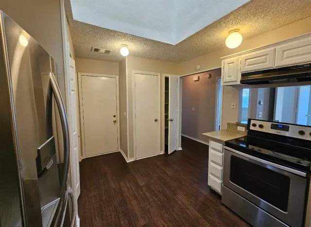 a kitchen with white cabinets and stainless steel appliances