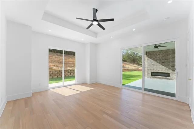 a view of an empty room with a window and a kitchen