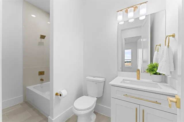 a bathroom with a granite countertop toilet a sink and a bathtub