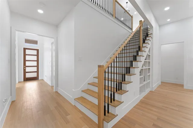 a view of a hallway with wooden floor and entryway